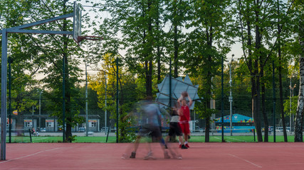 Fototapeta na wymiar young people enthusiastically play street basketball