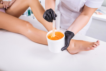 Slim woman with long legs coming to have sugaring in beauty salon