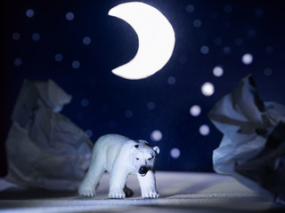 Toy polar bear under the moon and stars. The constellation URSA major.