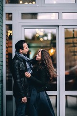  Loving couple in winter clothes in the city on the background of lights. European lovers on date 