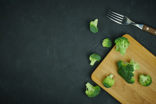 placer of broccoli green cabbage on a cutting board with a fork. Template of healthy food on a dark background. Copy space Top view. Vegetarian food. syroedenie.