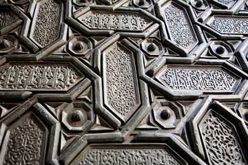 Background with Islamic patterns and Arabic calligraphy on door the 16th centure Seville Cathedral, Spain. Motifs in artworks of Andalusia