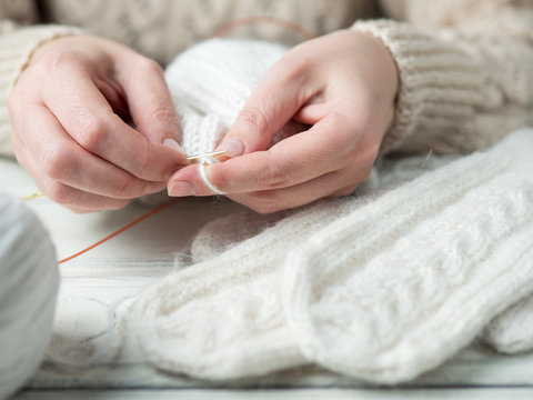 Woman knits winter warm clothes closeup