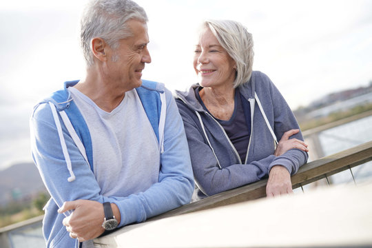 Healthy Senior Couple Smiling At Eachother Outdoors