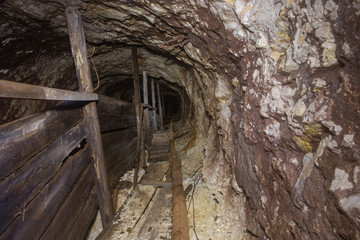 Fototapeta na wymiar Underground abandoned gold iron ore mine shaft tunnel gallery passage wtih wooden timbering