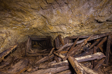 Underground abandoned gold iron ore mine shaft tunnel gallery passage wtih wooden timbering