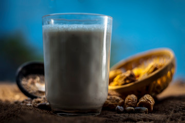 Close up of popular Indian and asian Winter drink on brown colroed gunny bag's surface i.e. Kharek ka dudh or dried dates milk consisting of milk,dried dates,cashews,almonds dry fruits and sugar.