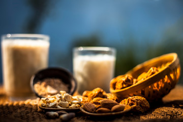 Close up of popular Indian and asian Winter drink on brown colroed gunny bag's surface i.e. Kharek ka dudh or dried dates milk consisting of milk,dried dates,cashews,almonds dry fruits and sugar.