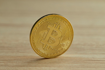 Golden Bitcoin coin on wood background