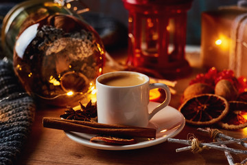 Cup of coffee in festive decorations with a fairy garland lights