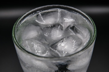Glass of pure water with ice cubes. Isolated on black background