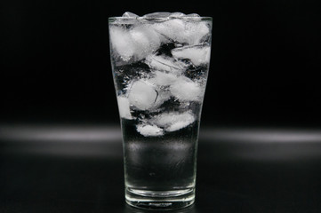 Glass of pure water with ice cubes. Isolated on black background