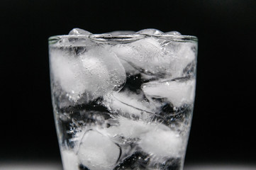 Glass of pure water with ice cubes. Isolated on black background
