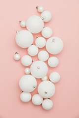 Christmas winter composition. White christmas balls on a pastel pink background