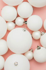 Christmas winter composition. White christmas balls on a pastel pink background