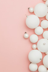 Christmas winter composition. White christmas balls on a pastel pink background