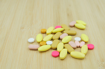 Assorted pharmaceutical medicine pills, tablets and capsules on glass bowl