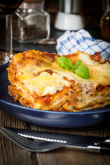 Piece of tasty hot lasagna with red wine.