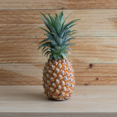 Ripe pineapple isolated on a wooden table