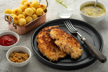 Wiener schnitzel with potato balls and lemon sauce. Chicken schnitzel in breading