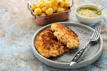 Wiener schnitzel with potato balls and lemon sauce. Chicken schnitzel in breading