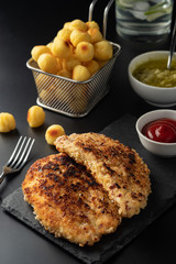 Wiener schnitzel with potato balls and lemon sauce. Chicken schnitzel in breading