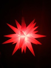 Herrnhuter Weihnachtsstern rot isoliert auf schwarz, Freisteller