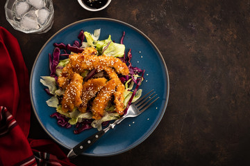 Salad with warm glazing chicken, sprinkled with sesame seeds. Chinese cuisine. Asian culture