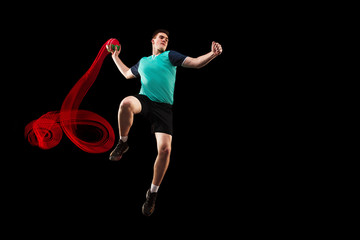 The fit caucasian young male handball player at studio on black background. Fit athlete isolated on...