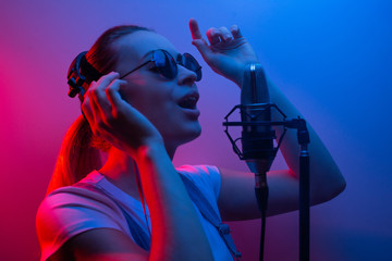 Young beautiful girl records vocals, show business, DJ, party, pop music
