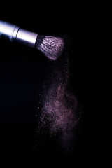 purple and pink powder color splash and brush for makeup artist or beauty blogger in black background, look like a galaxy and mystic mood.