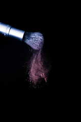 purple and pink powder color splash and brush for makeup artist or beauty blogger in black background, look like a galaxy and mystic mood.