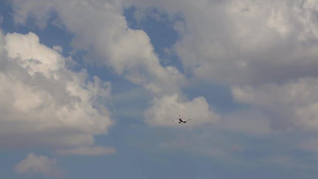 the plane is flying under the clouds