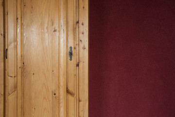brown wooden Closet doors close up with red bordeaux wall