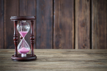hourglass on dark wooden background