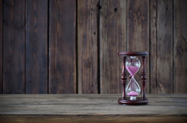 hourglass on dark wooden background