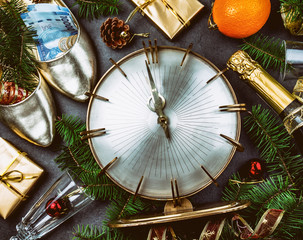 NEW YEAR CELEBRATION. Traditional put money to shoe for have money en New Year. Flat lay composition with vintage clock, shoes with dollars, champagne, Christmas decorations