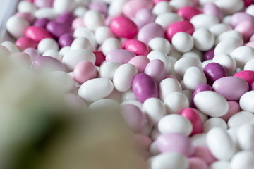 Pile of coated candies of white, purple and pink
