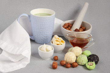Fat keto peanut butter, cheesecake, matcha balls and keto matcha coconut bulletproof tea in blue cup. keto protein balls and matcha tea recipes ingredients. it works ketogenic diet. blue background