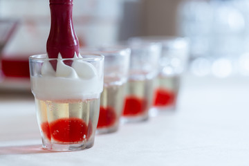 Putting creamy topping on alcohol shots
