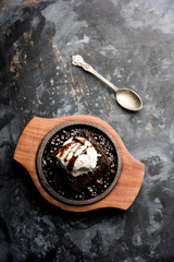 sizzling chocolate brownie is a sweet dish made using scoop of ice-cream on top served with a generous pouring of melted chocolate. server hot. selective focus