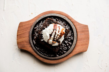 sizzling chocolate brownie is a sweet dish made using scoop of ice-cream on top served with a...