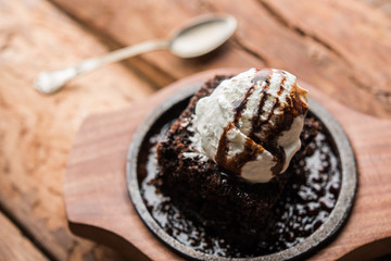 sizzling chocolate brownie is a sweet dish made using scoop of ice-cream on top served with a generous pouring of melted chocolate. server hot. selective focus