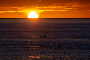 Naklejka na ściany i meble Scenic colorful sunrise over dark blue ocean water