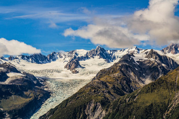 Travel New Zealand, beautiful nature/mountain background. Top scenic view of Fox Glacier Valley, Mount Cook and Southern Alps. Popular tourist/backpackers destination.