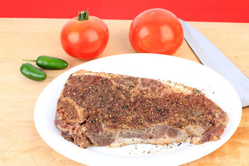 Sirloin Steak on Cutting Board with Peppers and Tomatoes