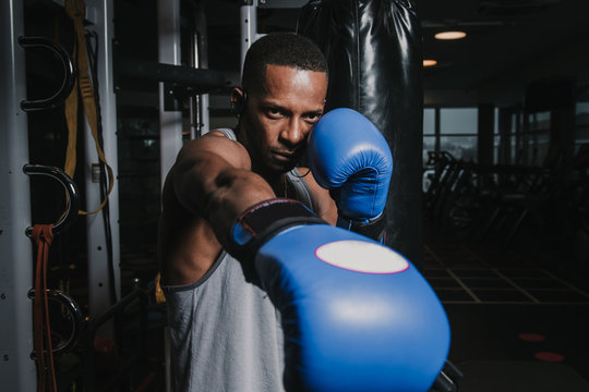 African American boxer training in gym