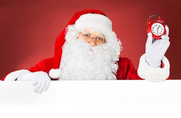 Santa claus holds a blank sign for your text