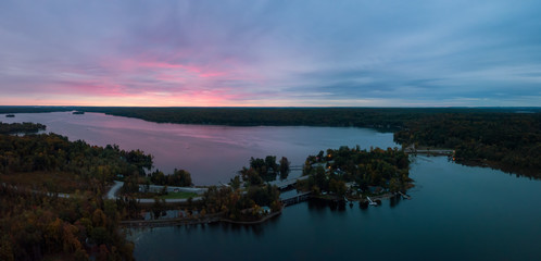 Obraz premium Aerial Panoramic view of Moira Lake during a striking and colorful sunrise. Taken in Madoc, Ontario, Canada.