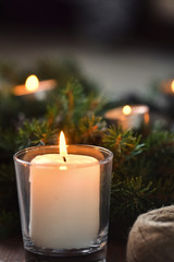 Advent decoration, wreath, candle. In the dark a candle in a beautiful decorative wreath is burning.